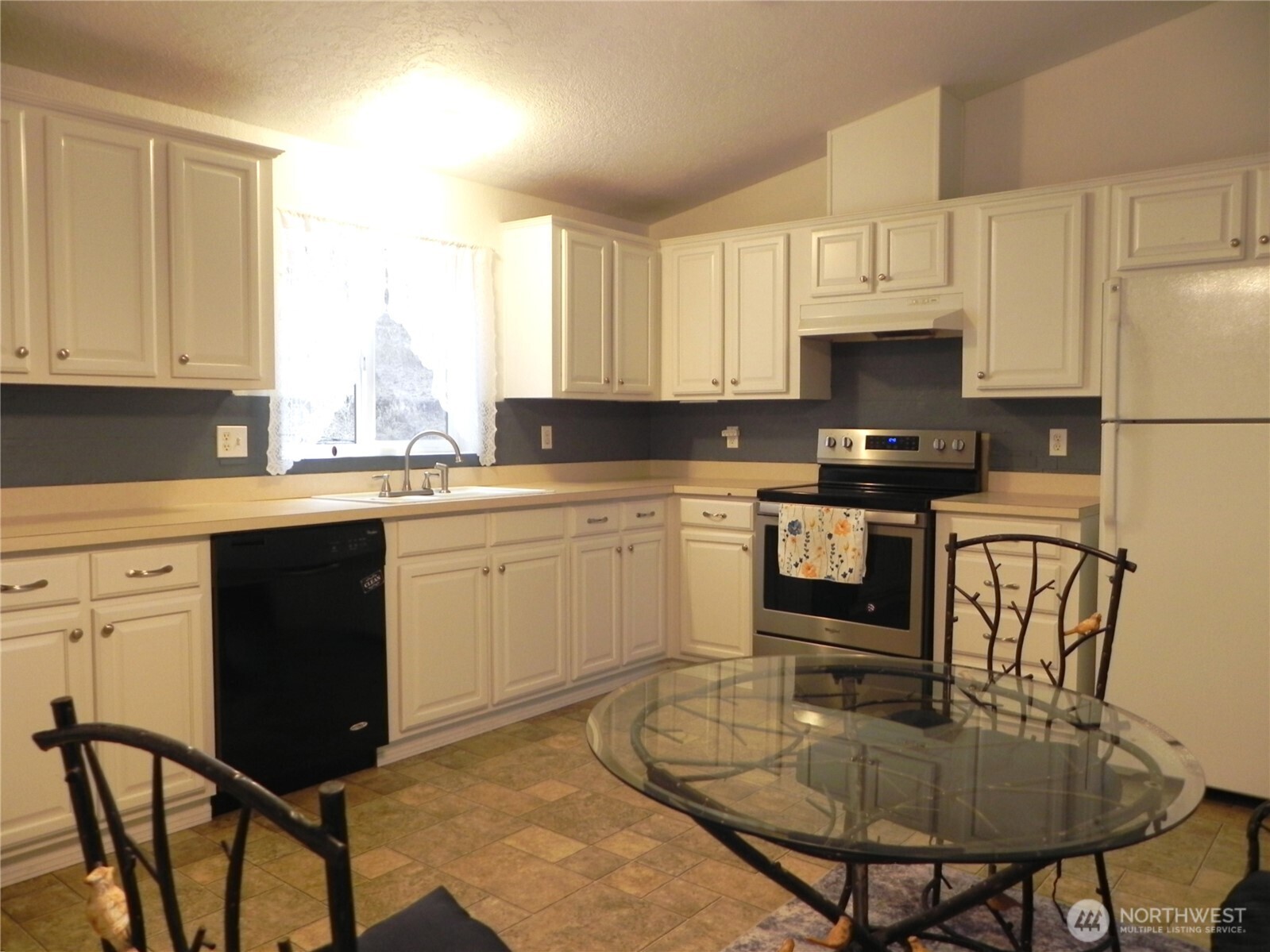 230 Silver Street Republic, WA 99166 - Photo 9 of 25 a kitchen with a stove a sink and white cabinets