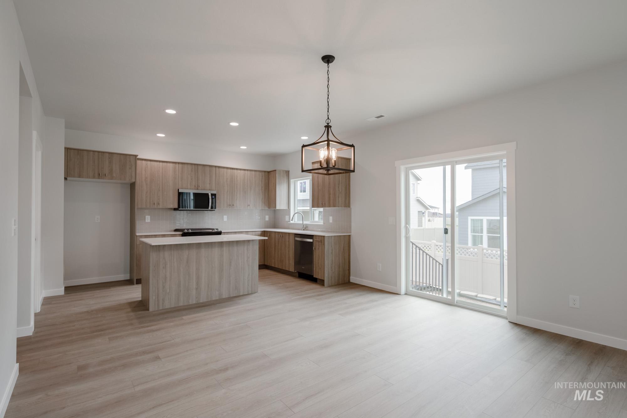10575 West Teratai Street Star, ID 83669 - Photo 9 of 26 Kitchen featuring a kitchen island, hanging light fixtures, light countertops, modern cabinets, and appliances with stainless steel finishes