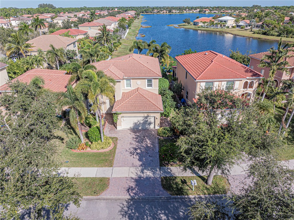 6258 Arlington Way Fort Pierce, FL 34951 - Photo 1 of 36 an aerial view of a house with a garden and lake view