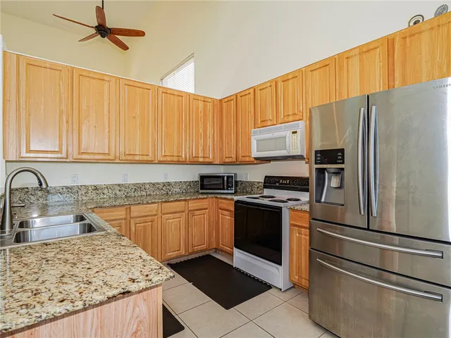 a kitchen with stainless steel appliances granite countertop a refrigerator sink and stove