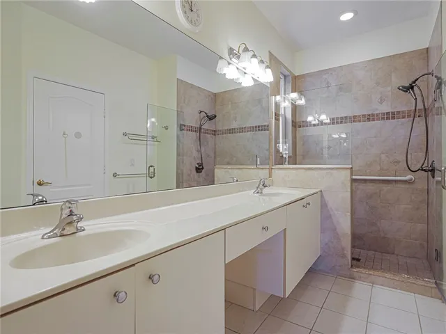 a bathroom with a double vanity sink mirror and shower
