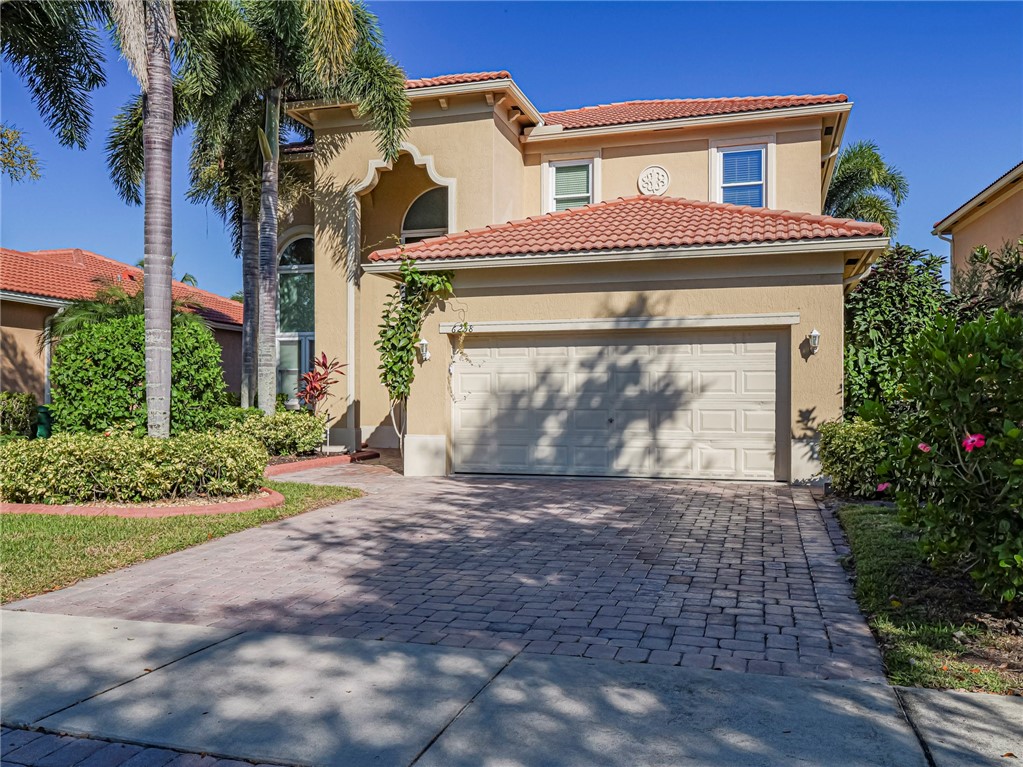 6258 Arlington Way Fort Pierce, FL 34951 - Photo 2 of 36 a front view of a house with a yard and garage