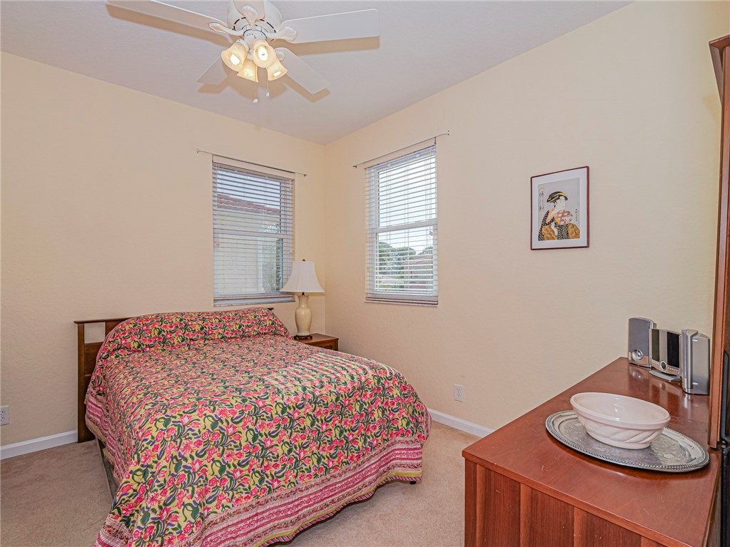 6258 Arlington Way Fort Pierce, FL 34951 - Photo 23 of 36 a bedroom with a bed and a chandelier