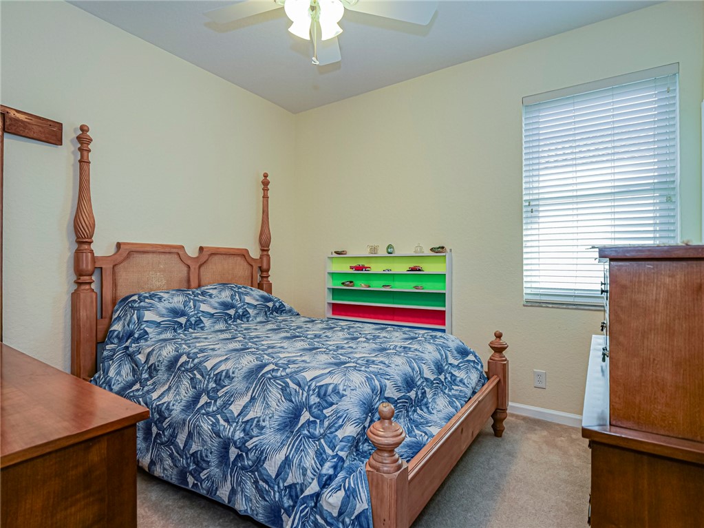 6258 Arlington Way Fort Pierce, FL 34951 - Photo 24 of 36 a bedroom with a bed and a dresser next to a window