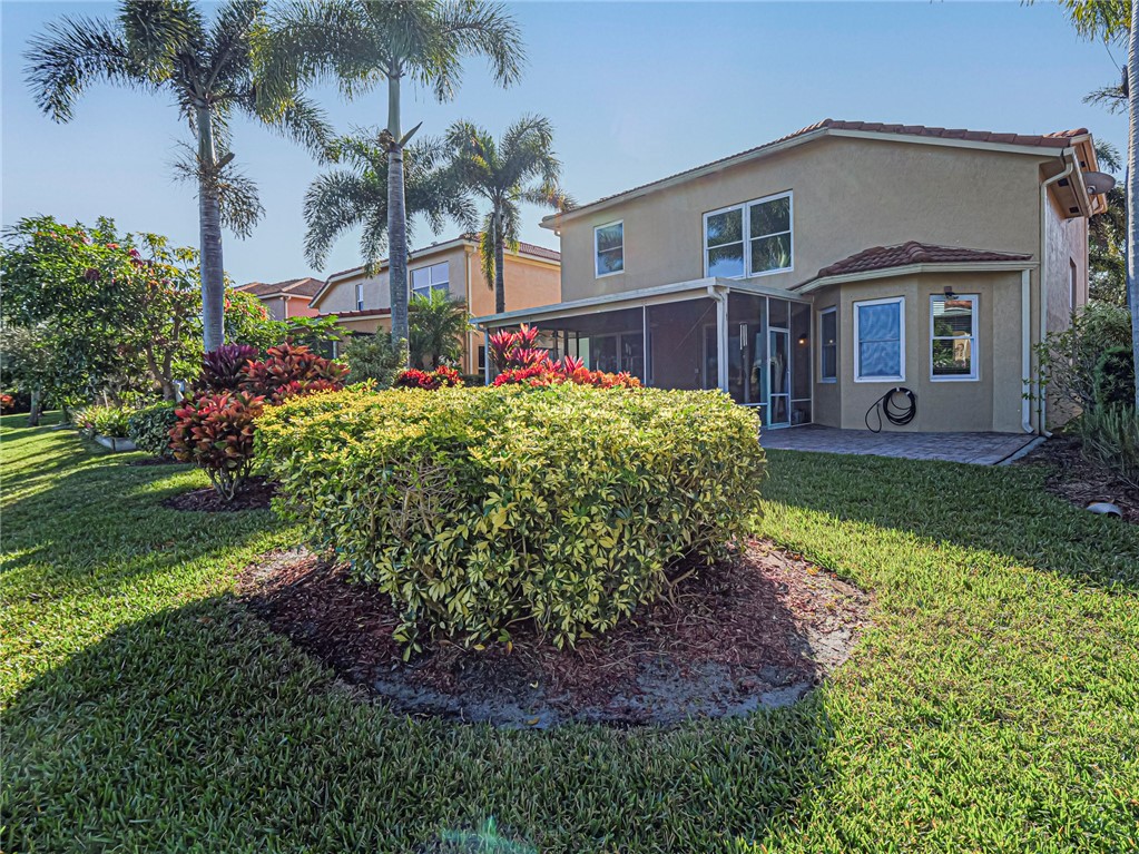 6258 Arlington Way Fort Pierce, FL 34951 - Photo 27 of 36 a front view of a house with a garden and trees