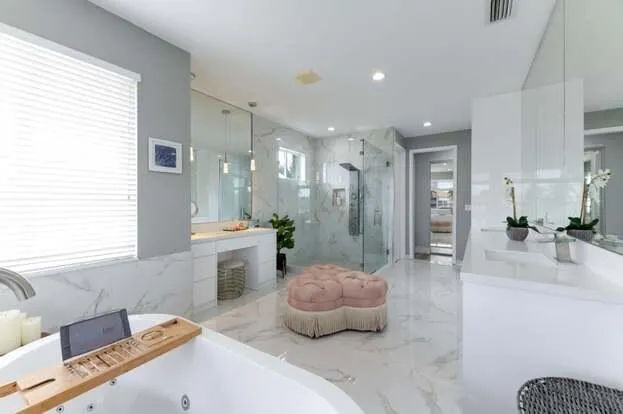 a bedroom with a beds chandelier and a window