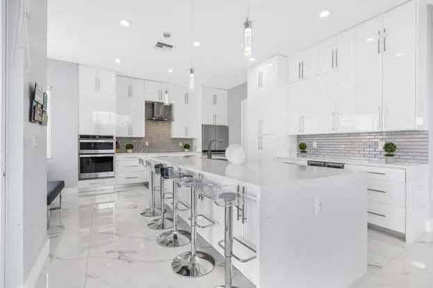 a kitchen with white cabinets and stainless steel appliances
