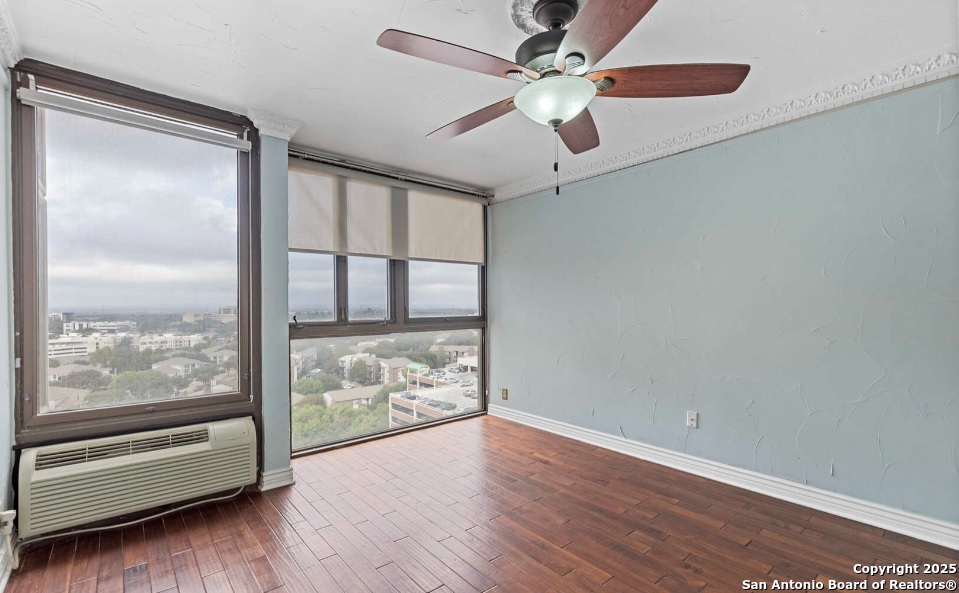 7701 Wurzbach Road, Unit 1205 San Antonio, TX 78229 - Photo 25 of 38 an empty room with wooden floor and door