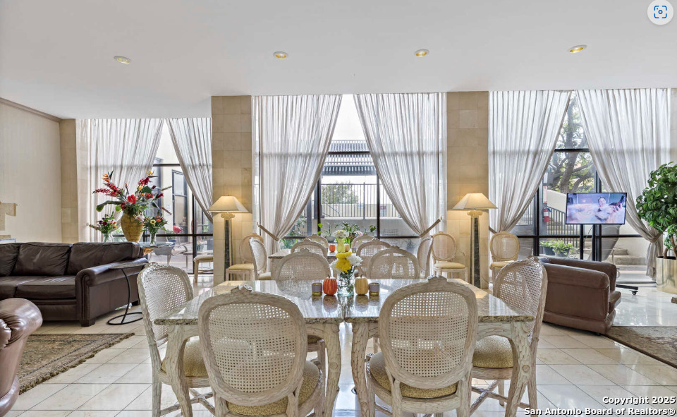 7701 Wurzbach Road, Unit 1205 San Antonio, TX 78229 - Photo 34 of 38 a dining room with furniture a large window and plants