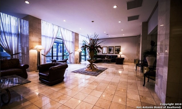 7701 Wurzbach Road, Unit 1205 San Antonio, TX 78229 - Photo 6 of 38 a living room with furniture gym equipment and a fireplace