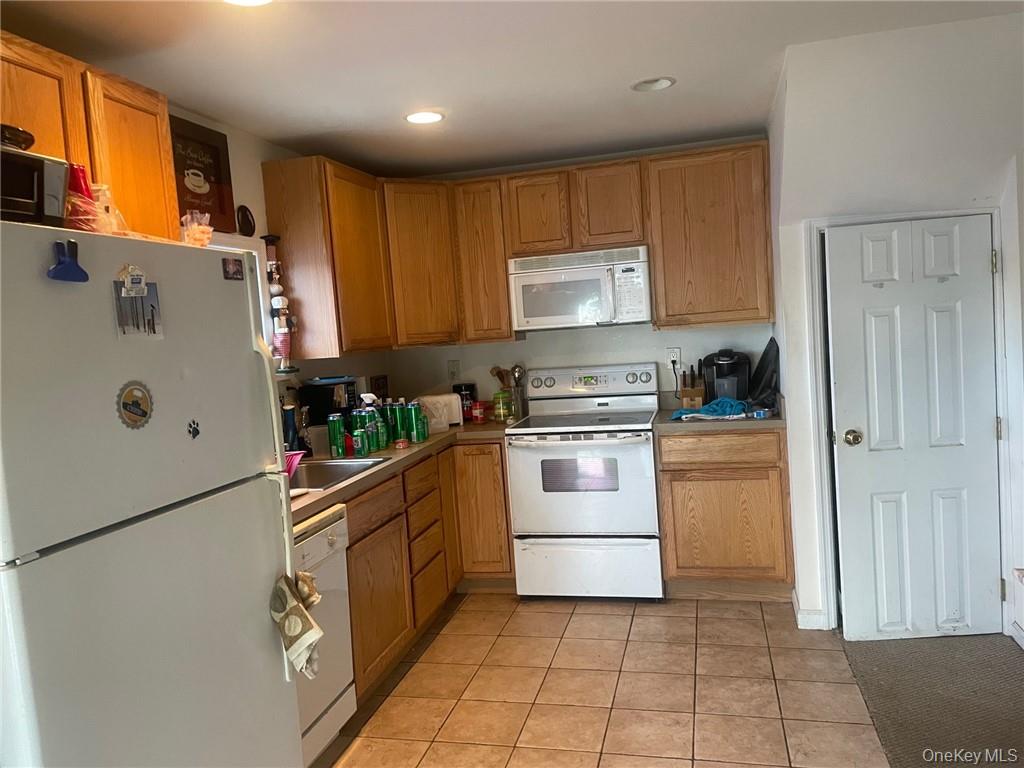 100 Dunderberg Road Putnam Valley, NY 10579 - Photo 22 of 29 a kitchen with a refrigerator a stove top oven and cabinets