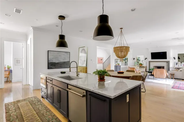 a kitchen with stainless steel appliances granite countertop a sink a stove and a wooden floors