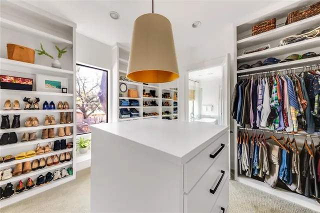 a view of walk in closet with clothes and shoes