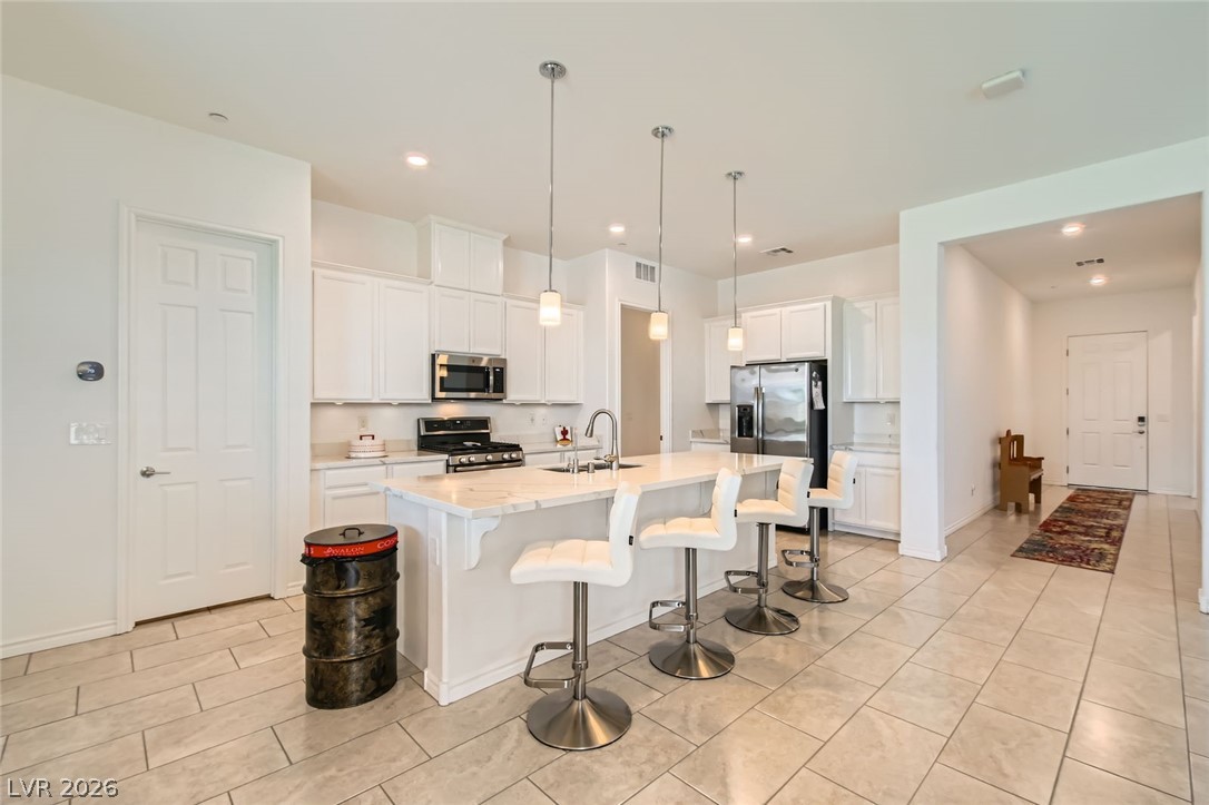 498 Pebble Run Avenue Henderson, NV 89011 - Photo 9 of 47 A well-appointed kitchen features a central island, ample cabinetry, and essential modern appliances.