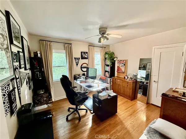 a living room with furniture hard wood floor and a flat screen tv