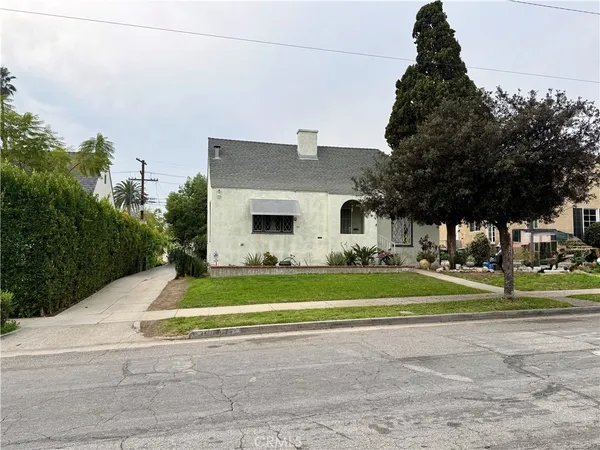 a front view of a house with a yard and trees