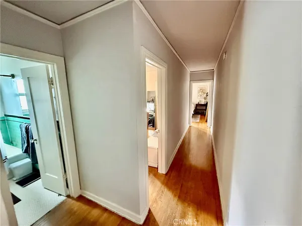 a view of a hallway with wooden floor and stairs