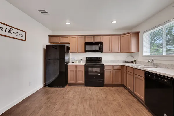 a kitchen with a refrigerator sink and wooden cabinets