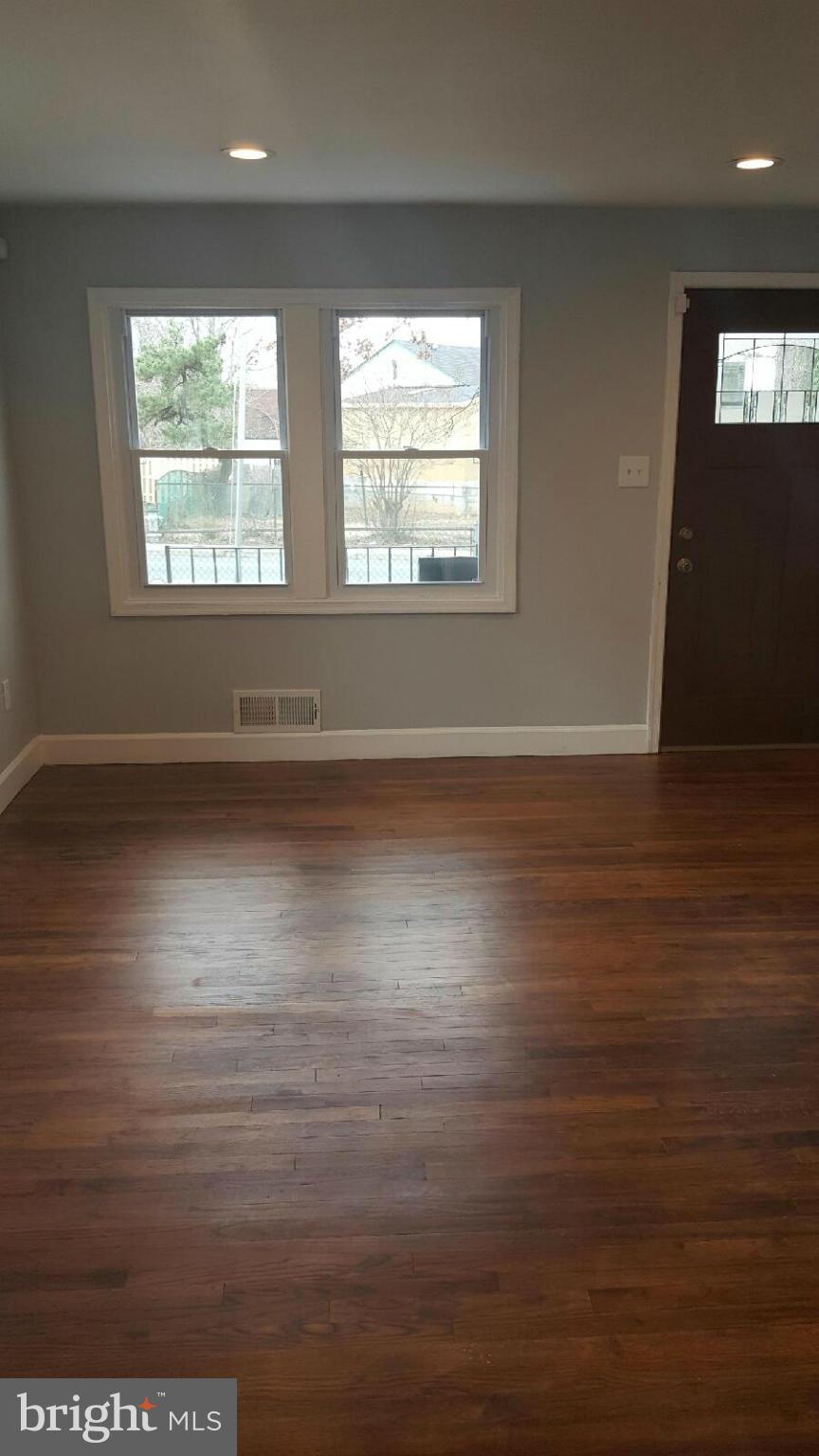 5100 Addison Road Capitol Heights, MD 20743 - Photo 4 of 10 an empty room with wooden floor and windows
