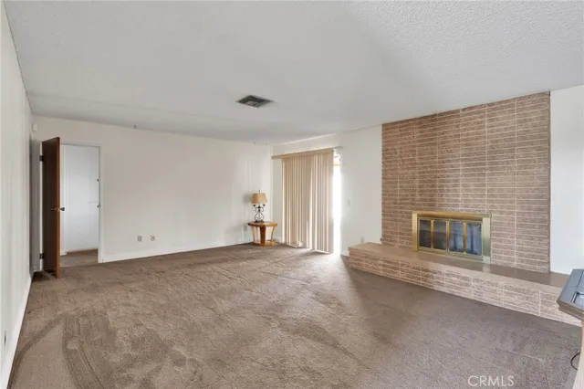 a view of empty room with a fireplace