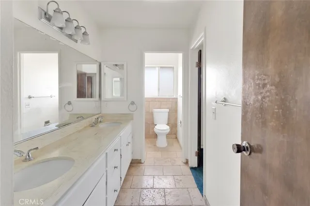 a spacious bathroom with a granite countertop sink mirror and a toilet