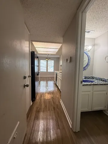 a view of a hallway with wooden floor and staircase