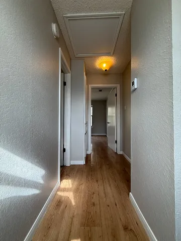 a view of a hallway with wooden floor