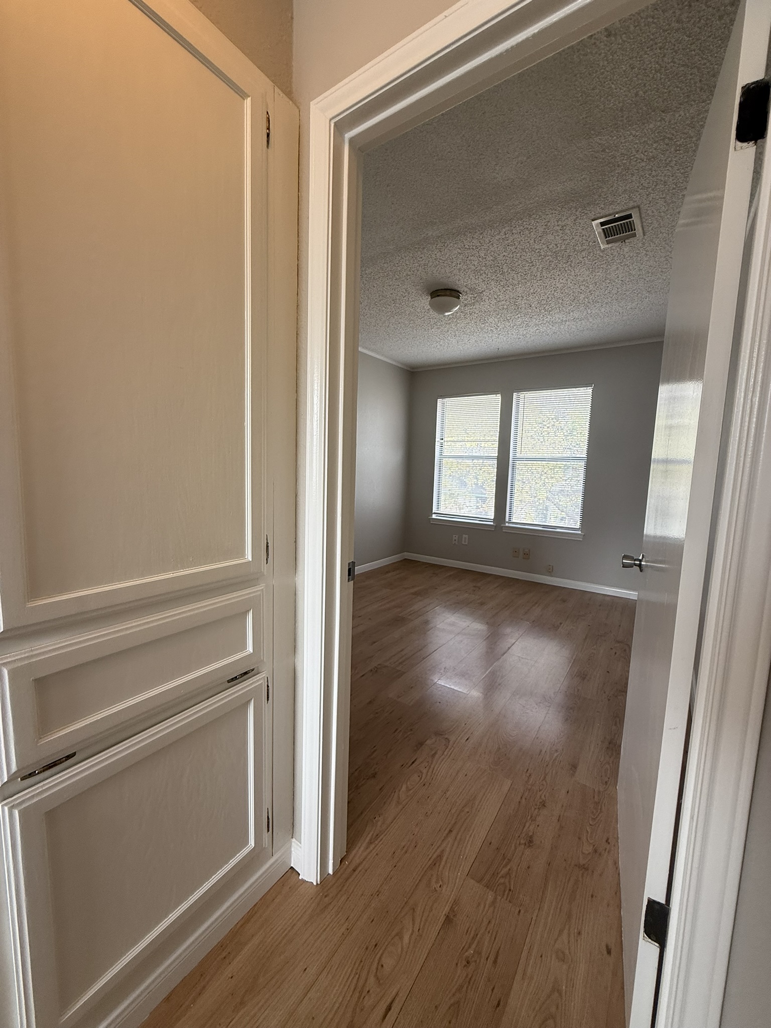 7806 Topawa Cove, Unit A Austin, TX 78729 - Photo 17 of 25 Corridor featuring a textured ceiling and light wood-style floors