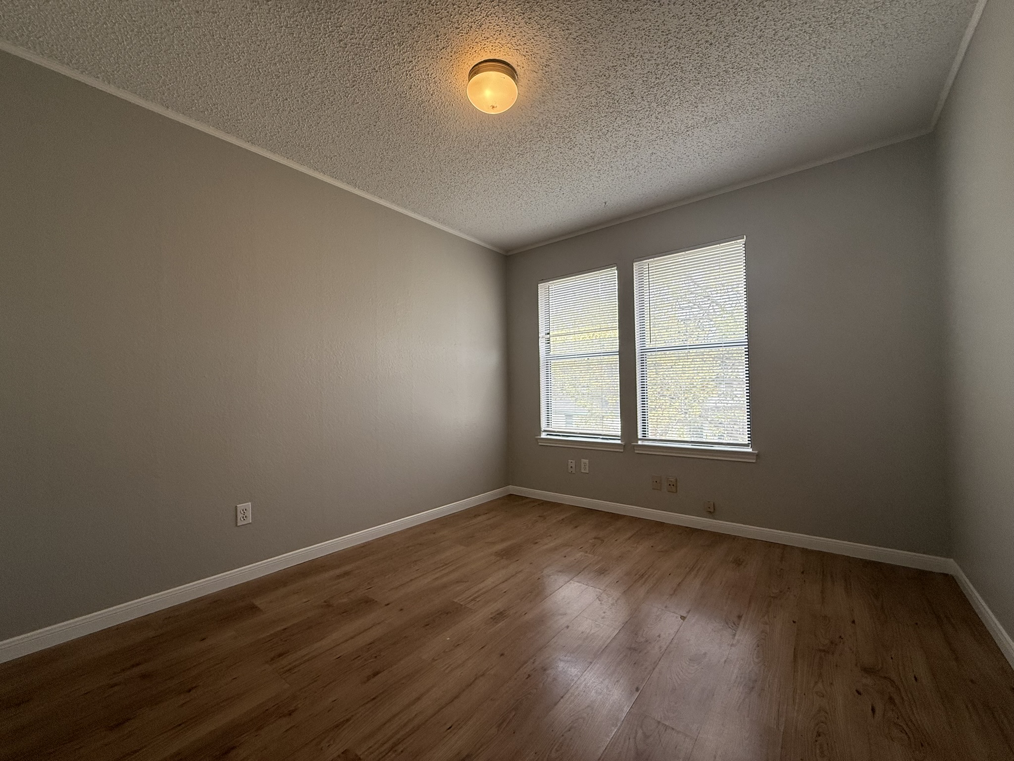 7806 Topawa Cove, Unit A Austin, TX 78729 - Photo 18 of 25 Spare room with hardwood / wood-style flooring, a textured ceiling, and ornamental molding