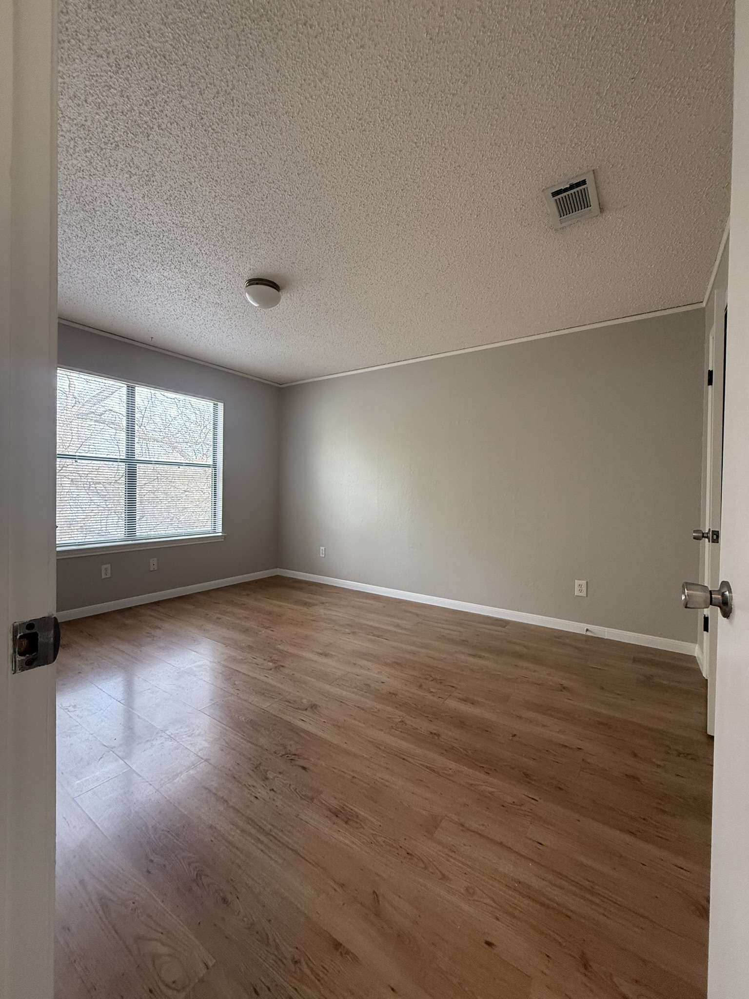 7806 Topawa Cove, Unit A Austin, TX 78729 - Photo 19 of 25 Unfurnished room featuring wood finished floors and a textured ceiling