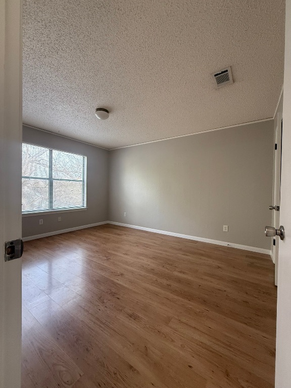 7806 Topawa Cove, Unit A Austin, TX 78729 - Photo 19 of 25 an empty room with wooden floor and windows