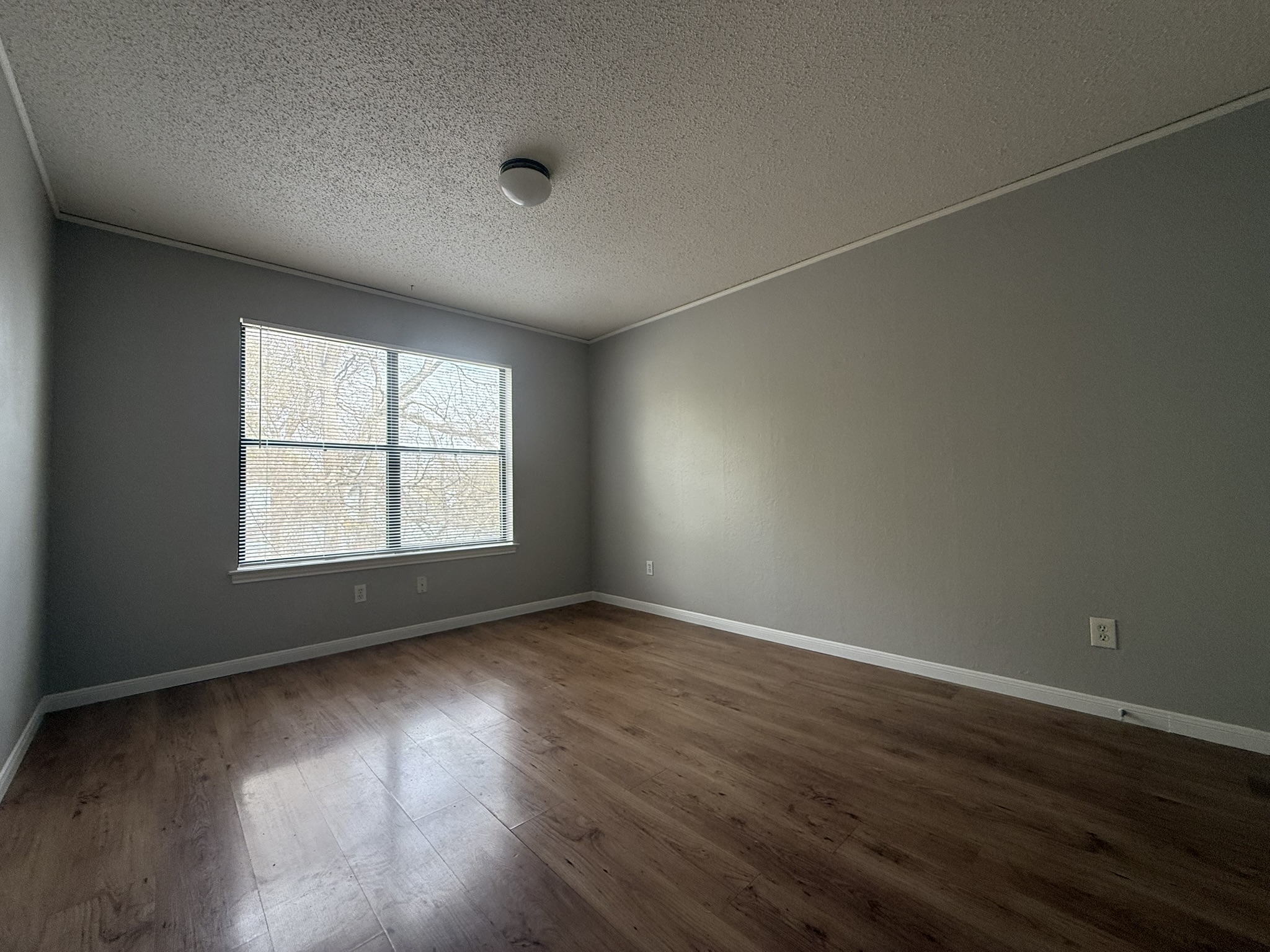 7806 Topawa Cove, Unit A Austin, TX 78729 - Photo 20 of 25 Empty room with a textured ceiling and dark wood finished floors