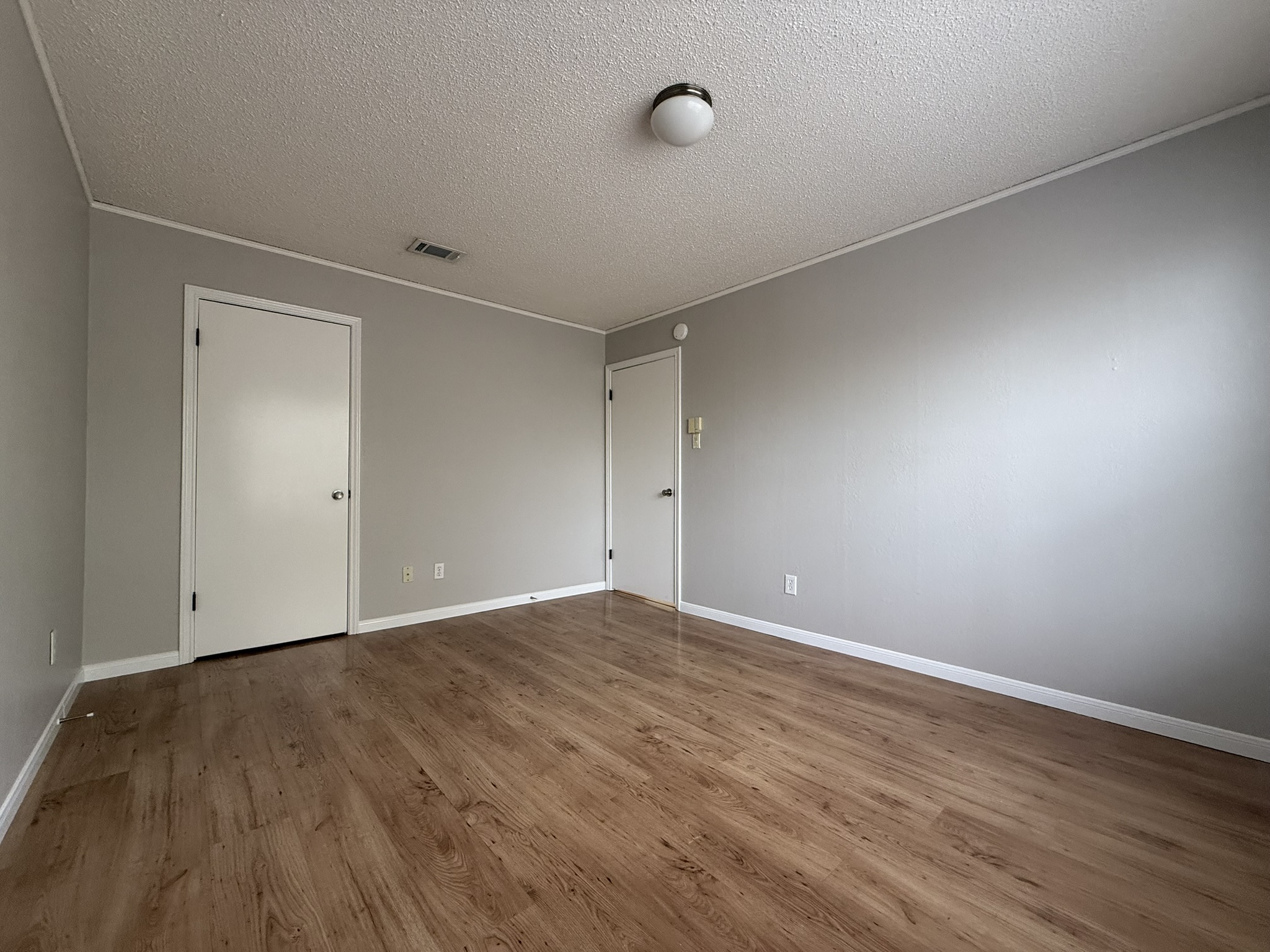 7806 Topawa Cove, Unit A Austin, TX 78729 - Photo 21 of 25 Empty room with a textured ceiling and wood finished floors