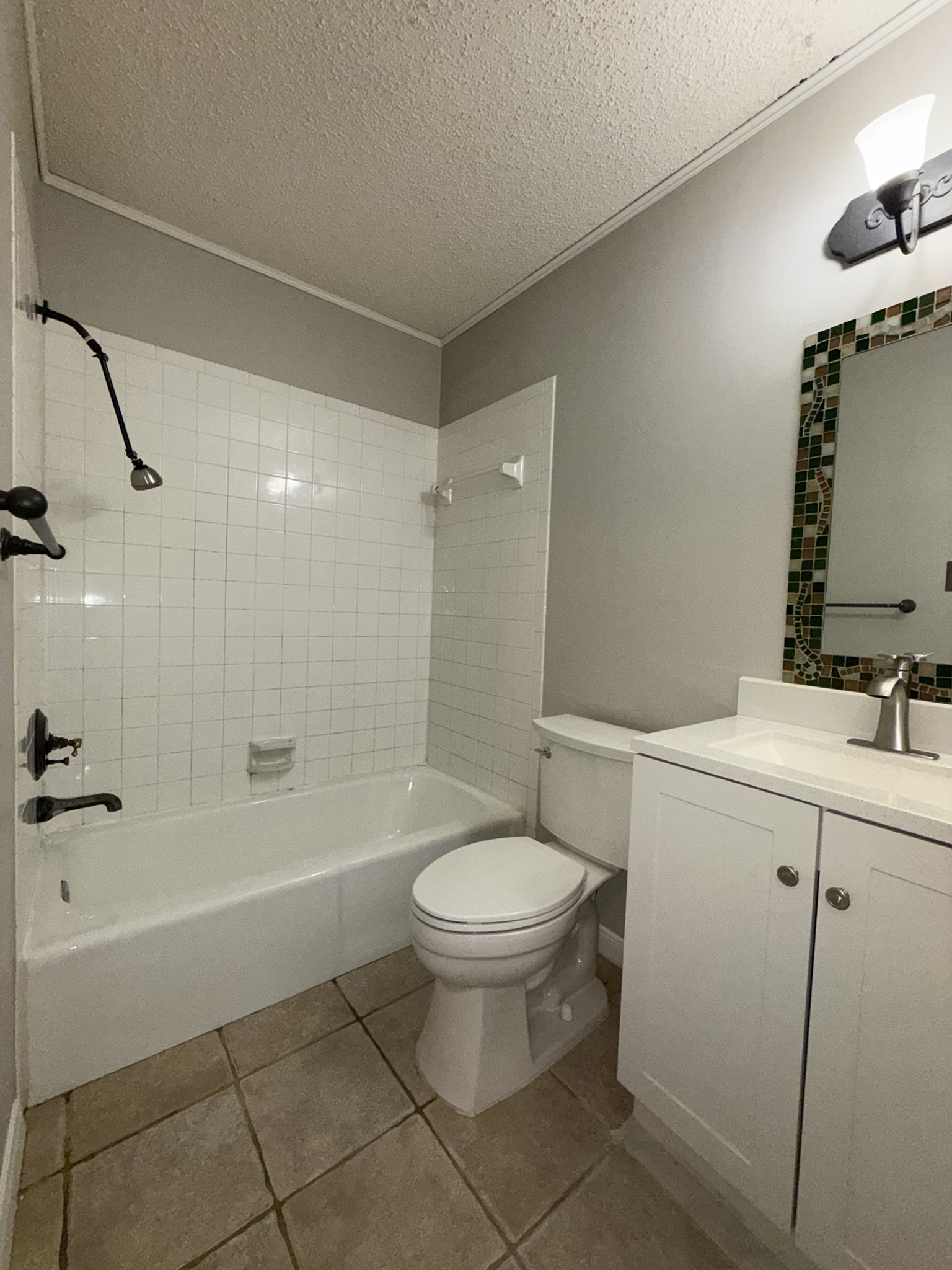7806 Topawa Cove, Unit A Austin, TX 78729 - Photo 22 of 25 Full bath with washtub / shower combination, light tile patterned floors, vanity, a textured ceiling, and crown molding