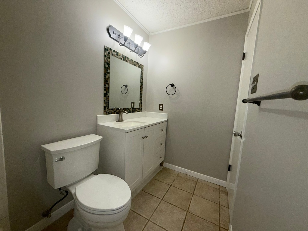 7806 Topawa Cove, Unit A Austin, TX 78729 - Photo 23 of 25 a bathroom with a toilet a sink and mirror