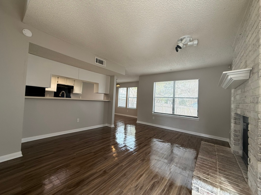 7806 Topawa Cove, Unit A Austin, TX 78729 - Photo 4 of 25 an empty room with wooden floor and windows