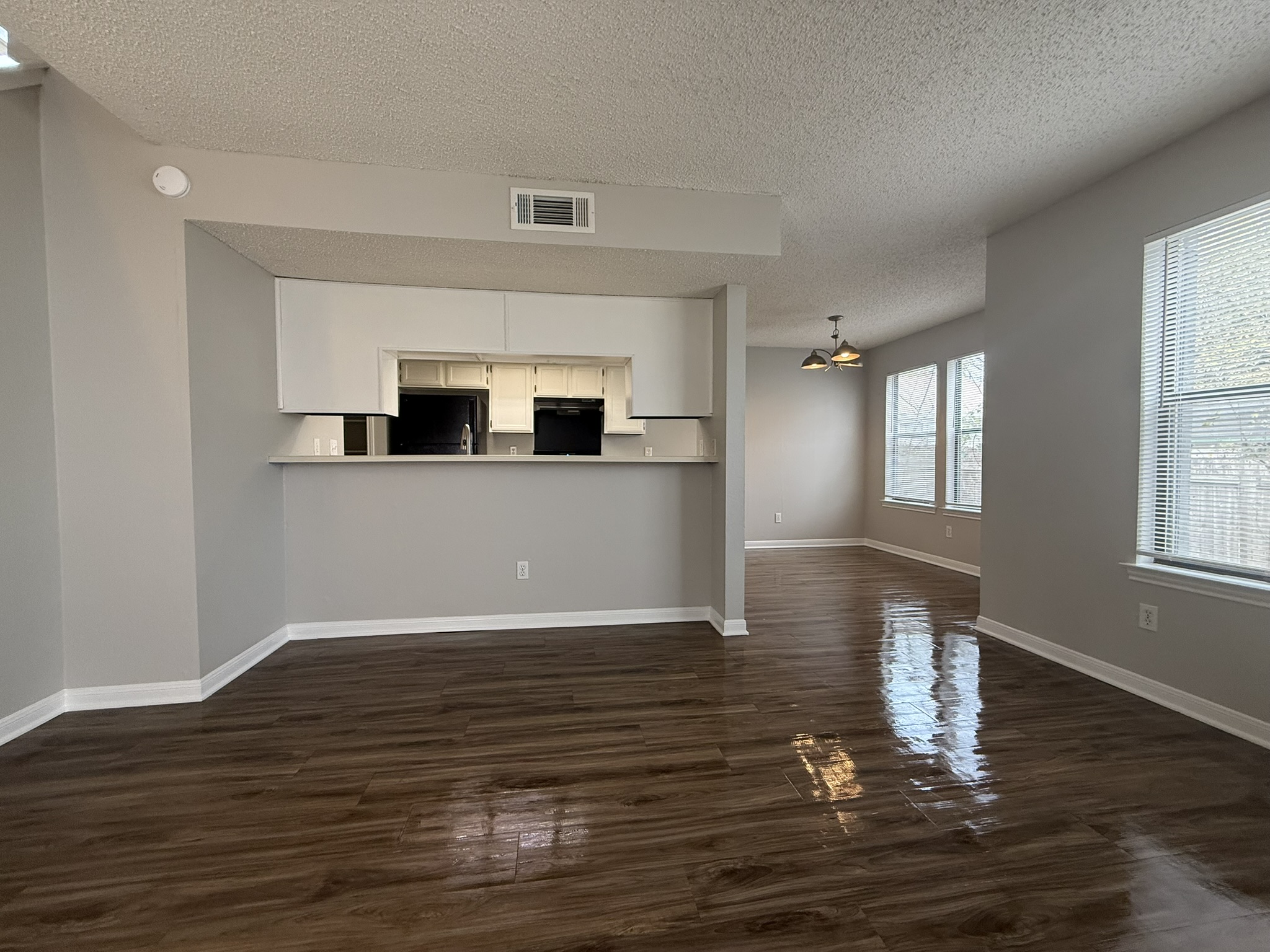 7806 Topawa Cove, Unit A Austin, TX 78729 - Photo 5 of 25 Unfurnished living room with dark wood-style flooring and a textured ceiling