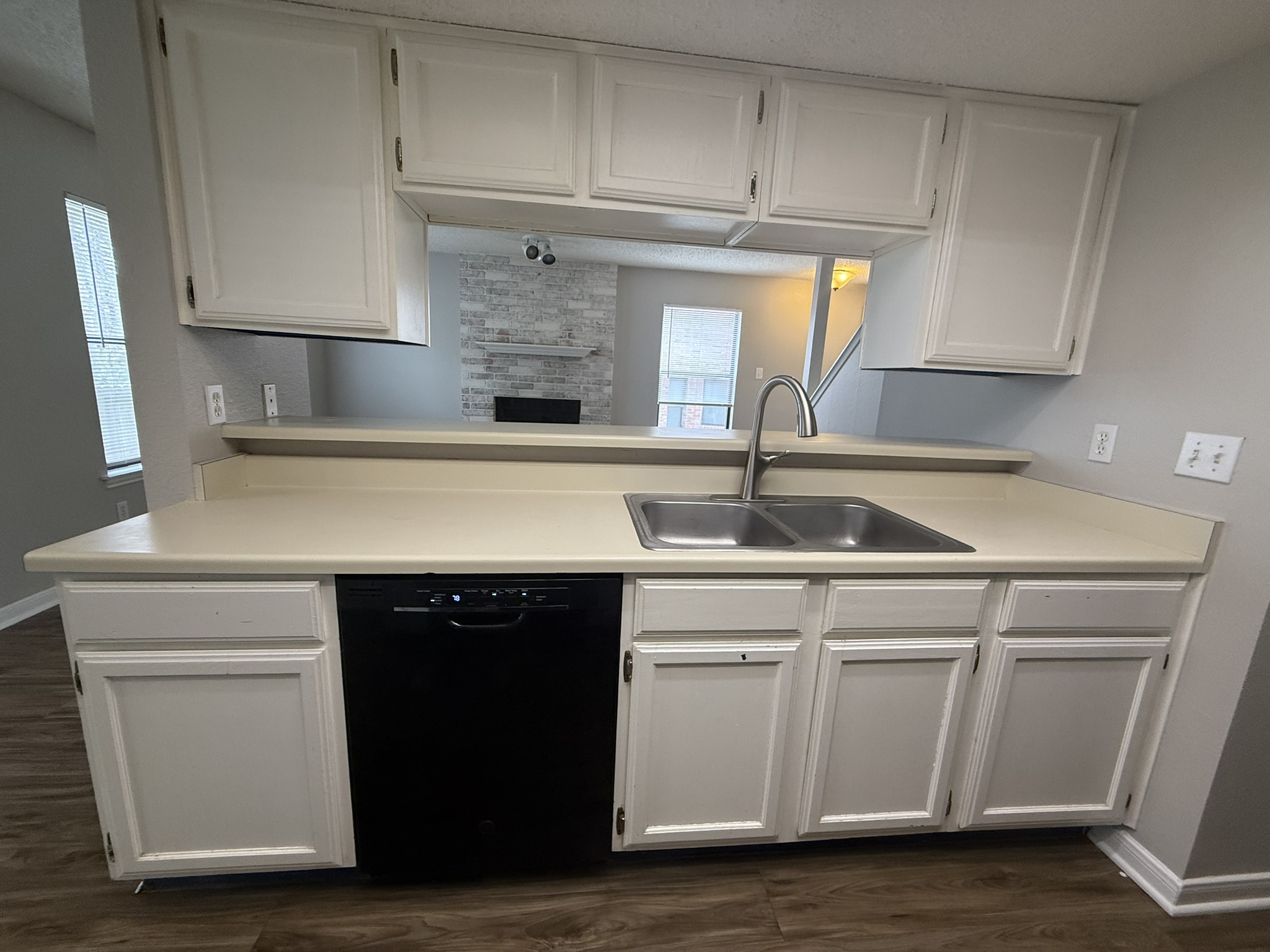 7806 Topawa Cove, Unit A Austin, TX 78729 - Photo 9 of 25 Kitchen with white cabinets, light countertops, dishwasher, and dark wood-style flooring