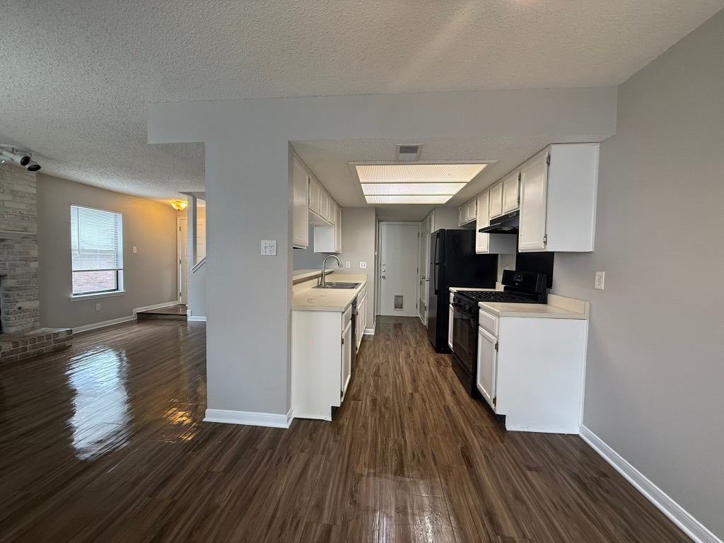 7806 Topawa Cove, Unit A Austin, TX 78729 - Photo 10 of 25 a kitchen with sink cabinets and wooden floor