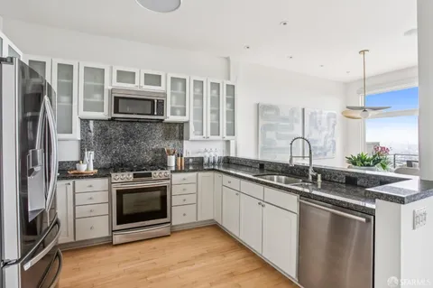 a kitchen with stainless steel appliances granite countertop a sink stove oven and refrigerator