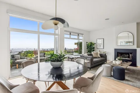 a living room with furniture a fireplace and a chandelier