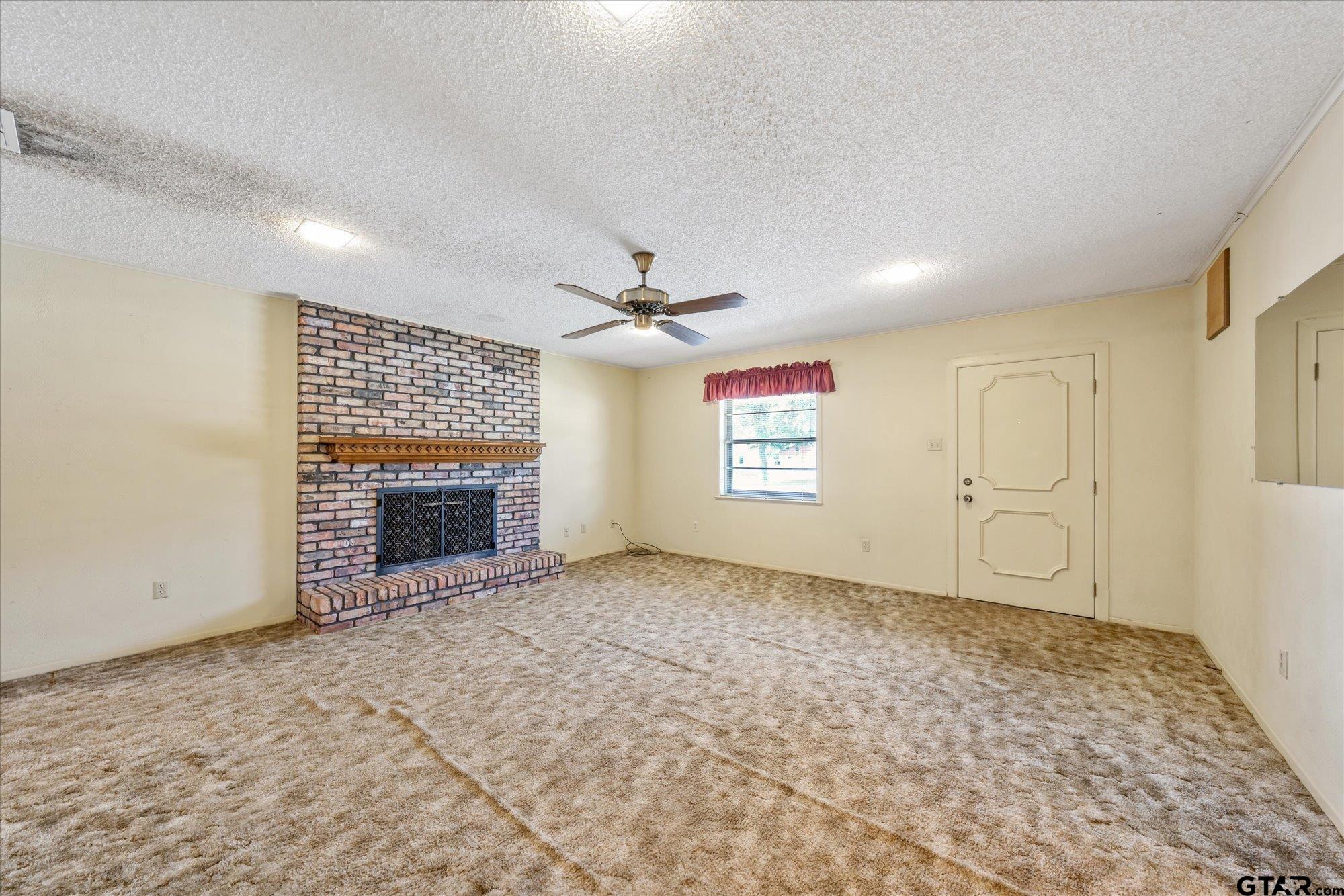 13791 Maple Drive Tyler, TX 75709 - Photo 4 of 26 an empty room with windows and fireplace