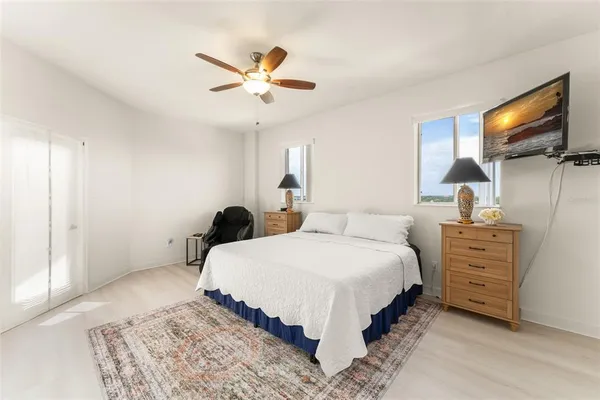 a bedroom with a bed and a ceiling fan