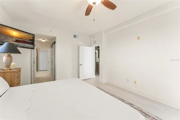 a bedroom with a large bed and a chandelier