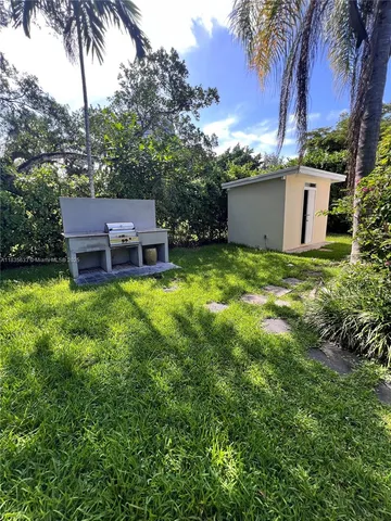 aerial view of a house with a yard and a tree