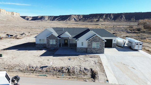2350 North 1075 West Helper, UT 84526 - Photo 47 of 49 View of front of property with stone siding, driveway, a garage, and a mountain view