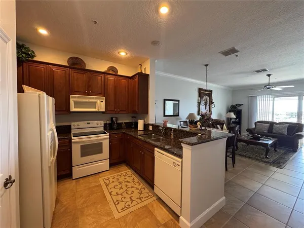 a kitchen with granite countertop a sink and stainless steel appliances
