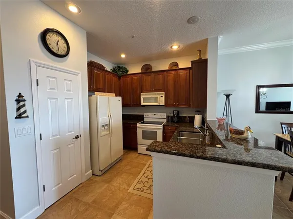 a large kitchen with stainless steel appliances granite countertop a stove a refrigerator and a sink