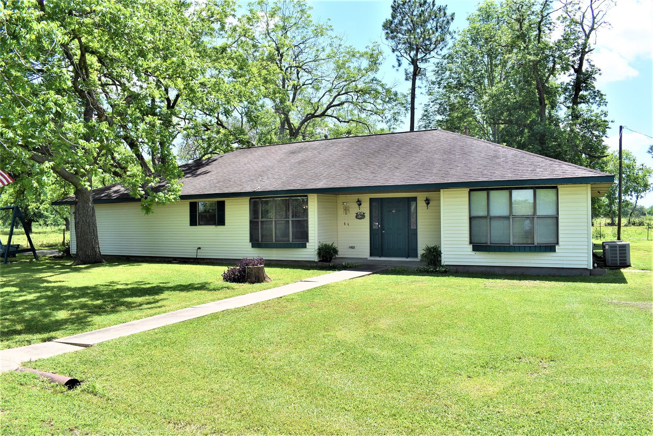 8854 FM 524 Road Sweeny, TX 77480 - Photo 2 of 45 a front view of a house with a garden and trees
