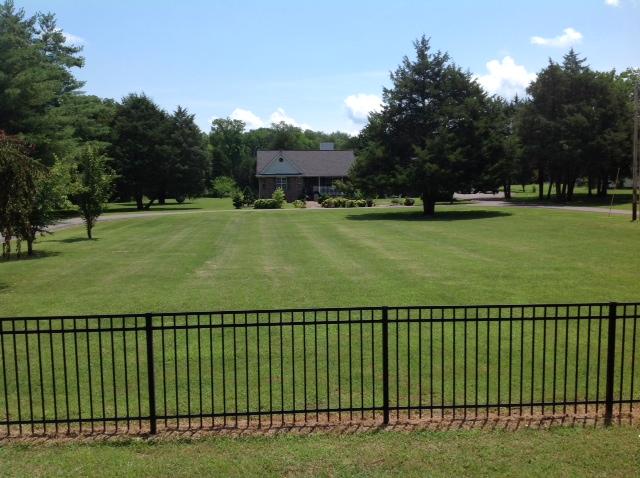 front of house and nice big yard with fence in front